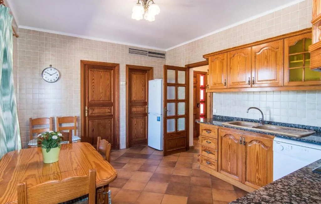 Traditional kitchen and dining area with wooden cabinetry, tiled floor, and dining table at Finca Bloom